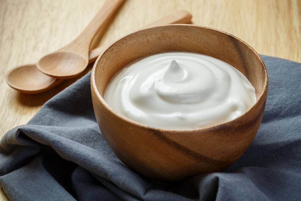 a bowl of yogurt and two spoons on the table