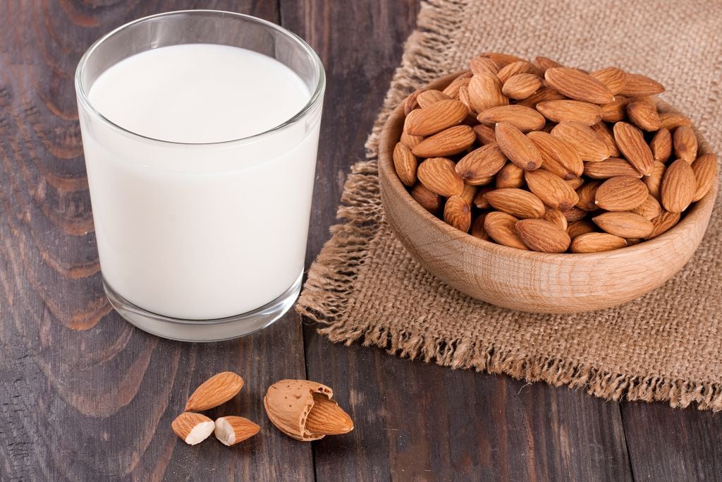 A cup of Almond Milk and a bowl of almost on the table