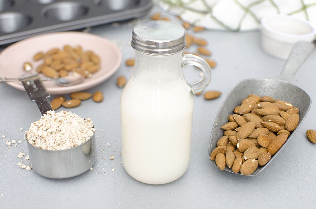A bottle of Almond Milk and a plate of almost on the table