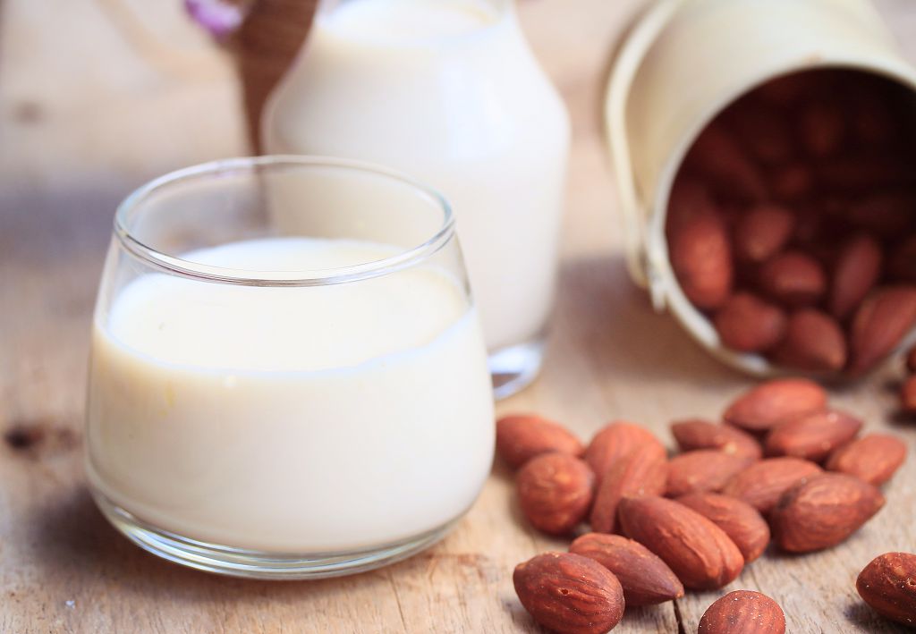 A cup of Almond Milk and almost on the table