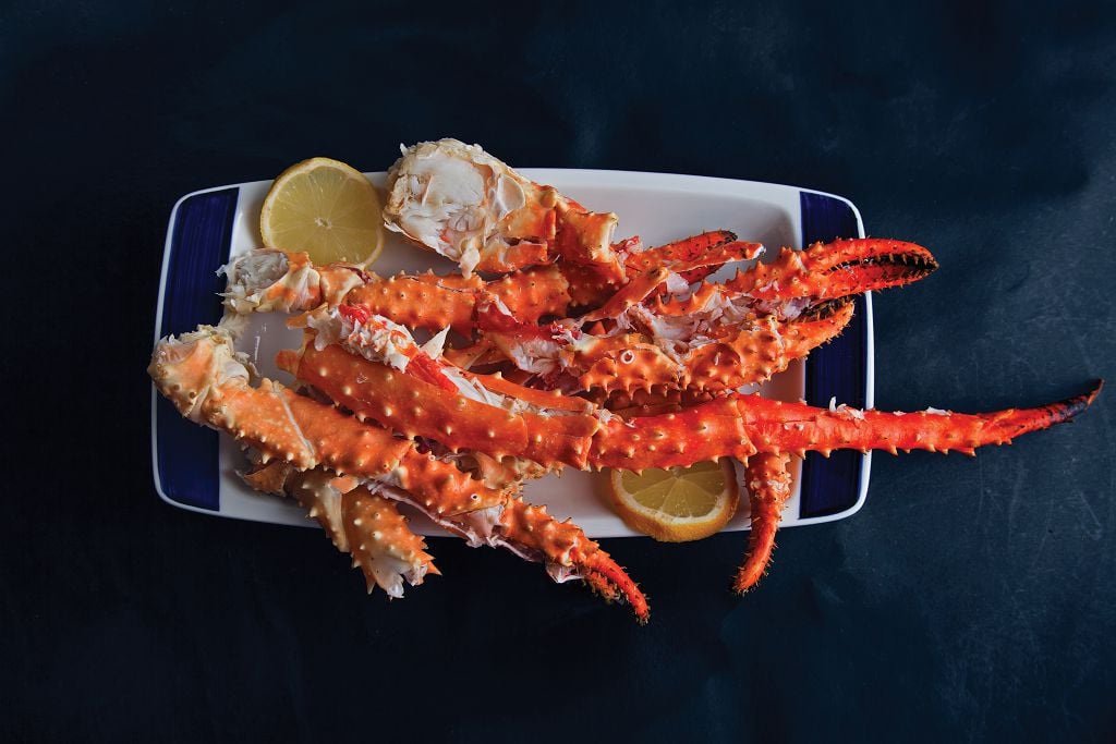 A plate of crab legs and slices of lemon