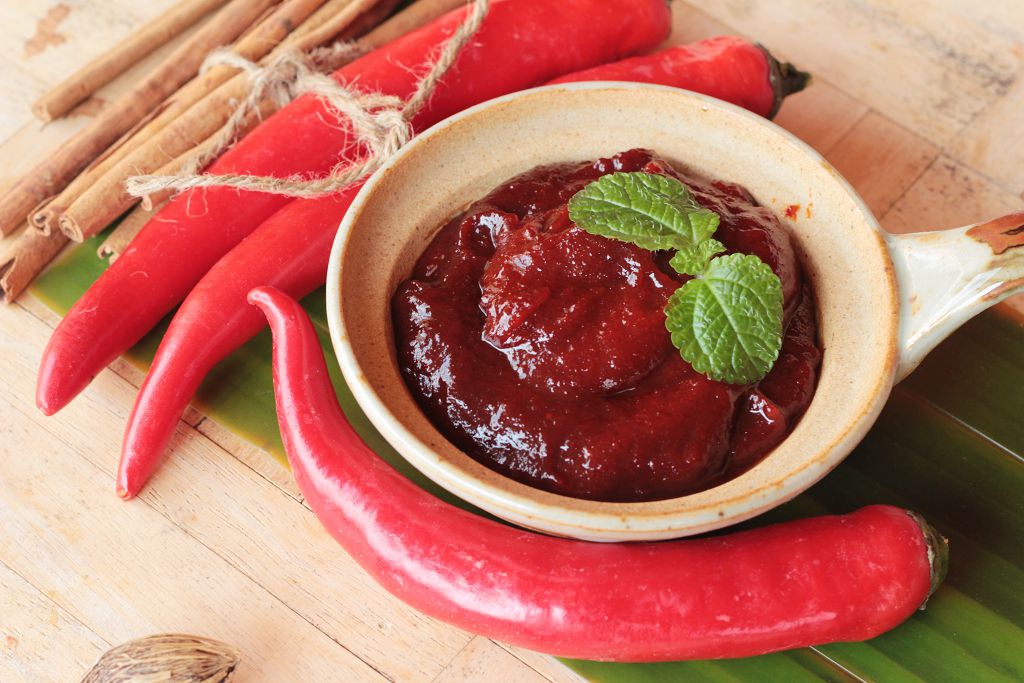 a bowl of Gochujang and chili pepper on the table