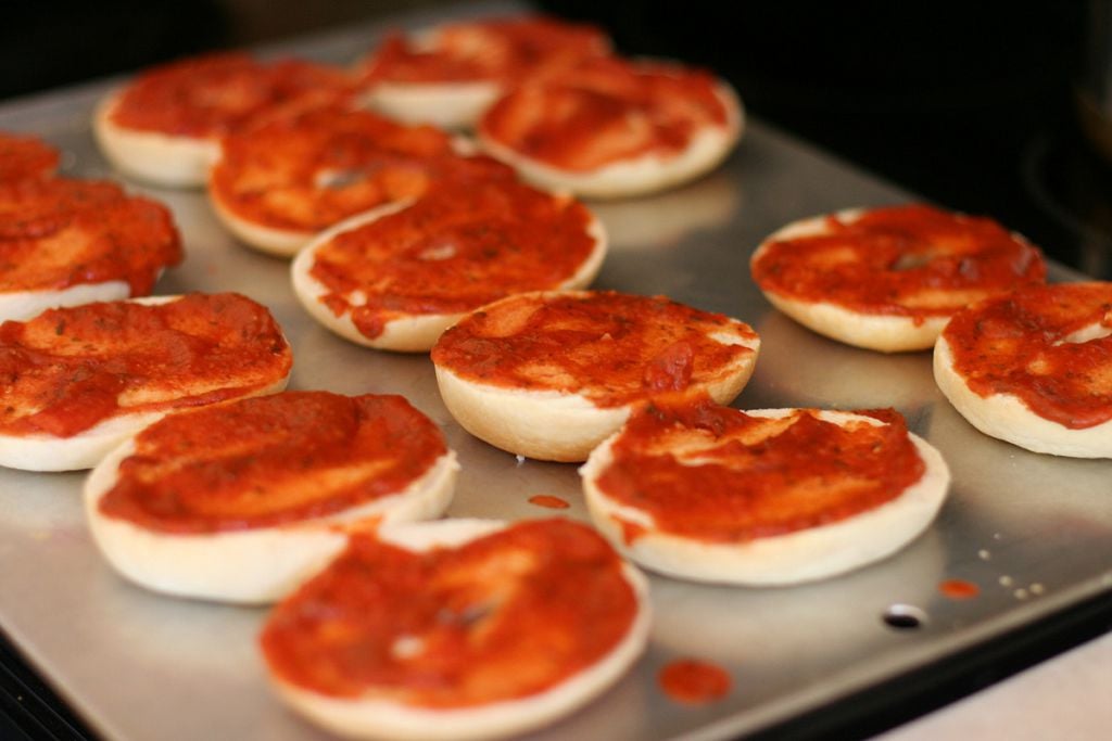 Spread a tablespoon of pizza sauce over each half of bagel.