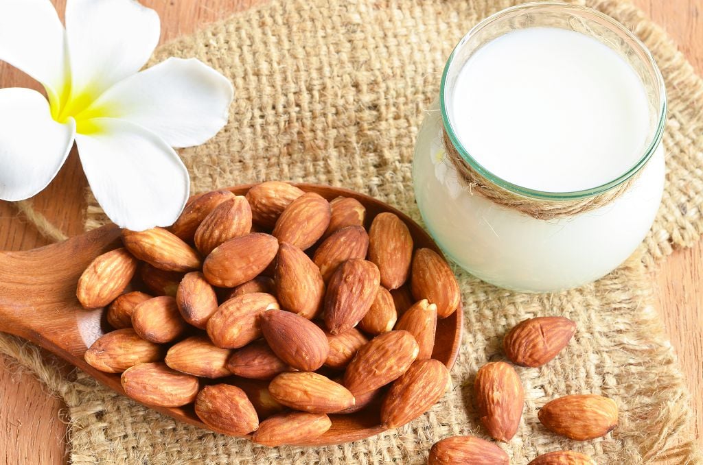 A bottle of Almond Milk and a spoon of Almond