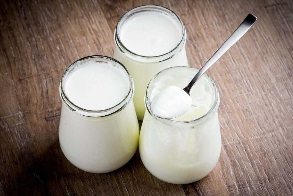 bottles of Greek Yogurt and a spoon on the table