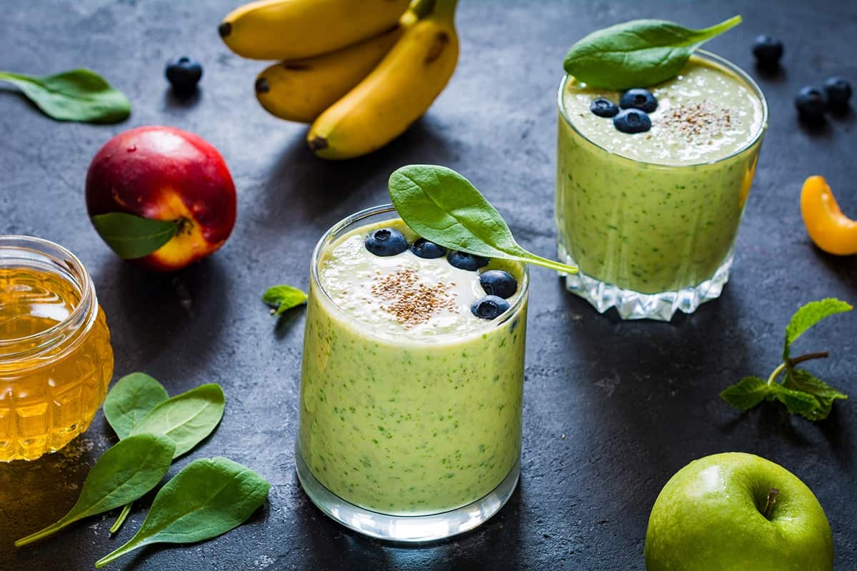 Cups of Collard Greens-Berries Smoothie and fruits