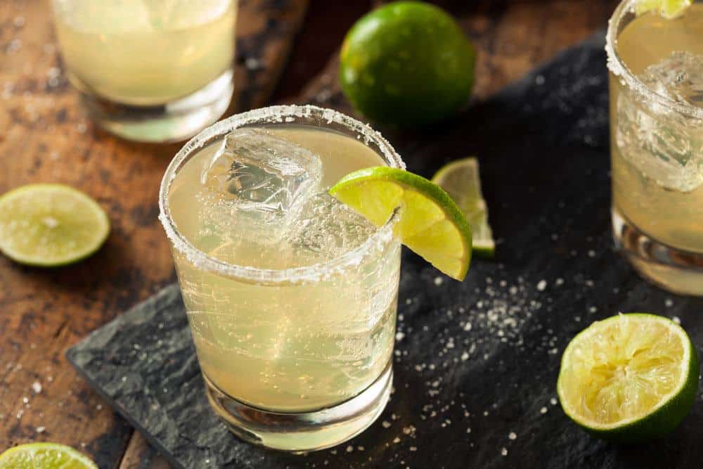 Cups of Margarita and slices of lime on the table