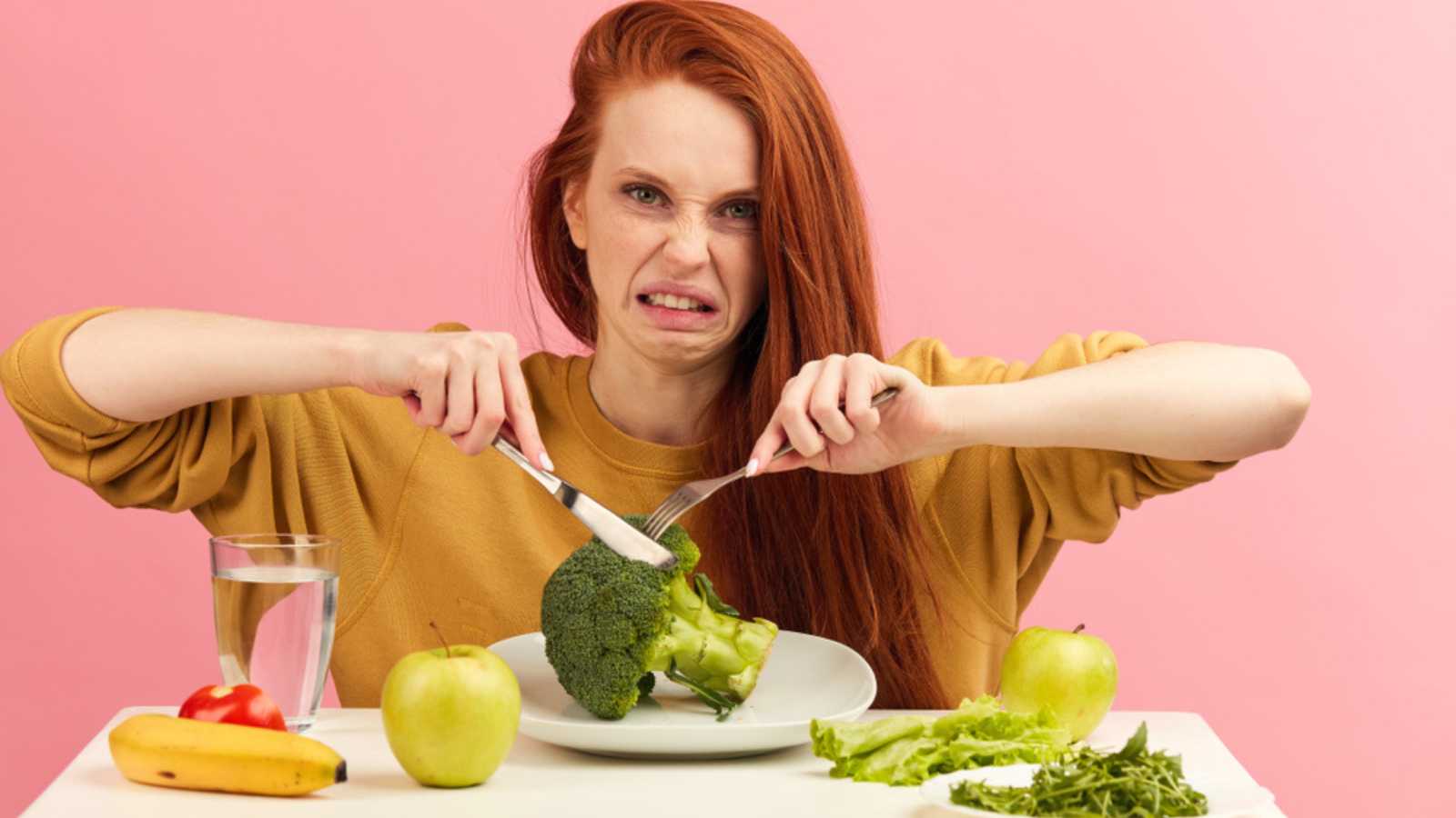Woman trying to cut broccoli