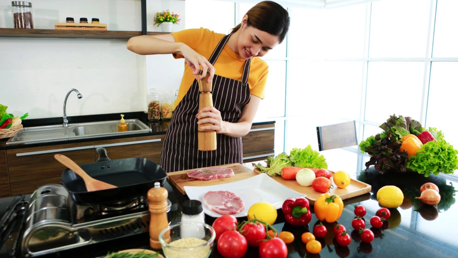 Woman cooking and seasoning meat