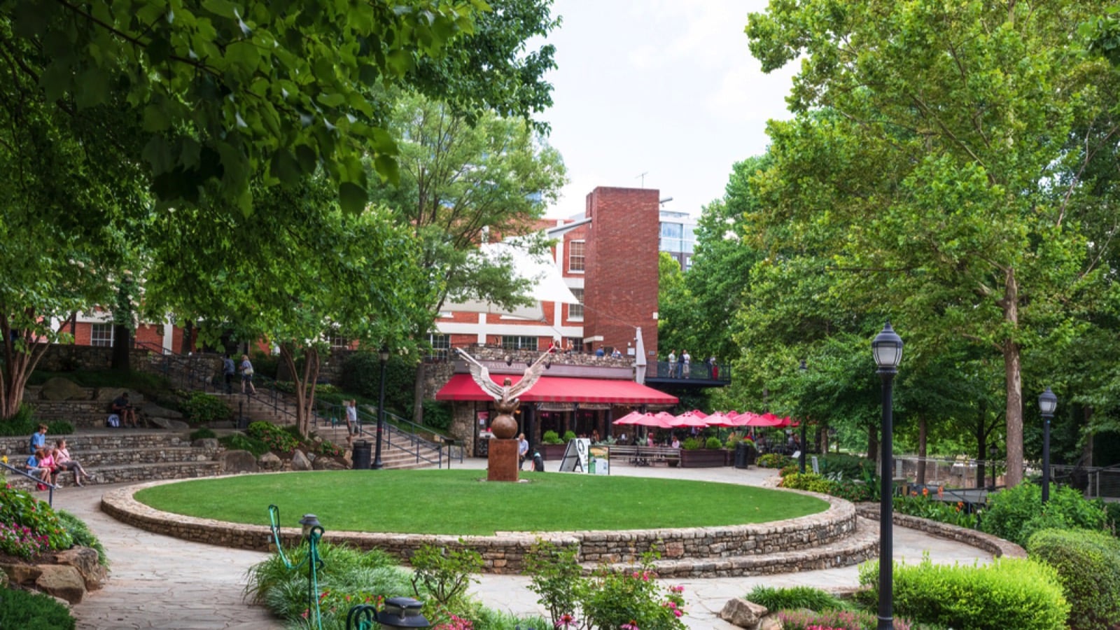 GREENVILLE, SC, USA-23 JUNE 2021: Falls Park on the Reedy, with people enjoying a warm summer day. Passerelle Bistro is shown.